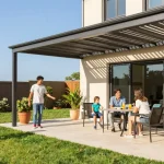 Moderne Terrassenüberdachung mit Aluminium-Pergola, Familie genießt sonnigen Tag im Freien.
